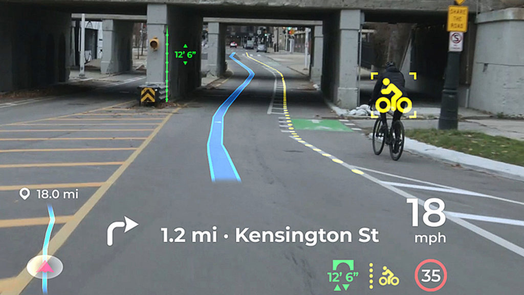 Panasonic driver assist system warns of a bicycle rider ahead.